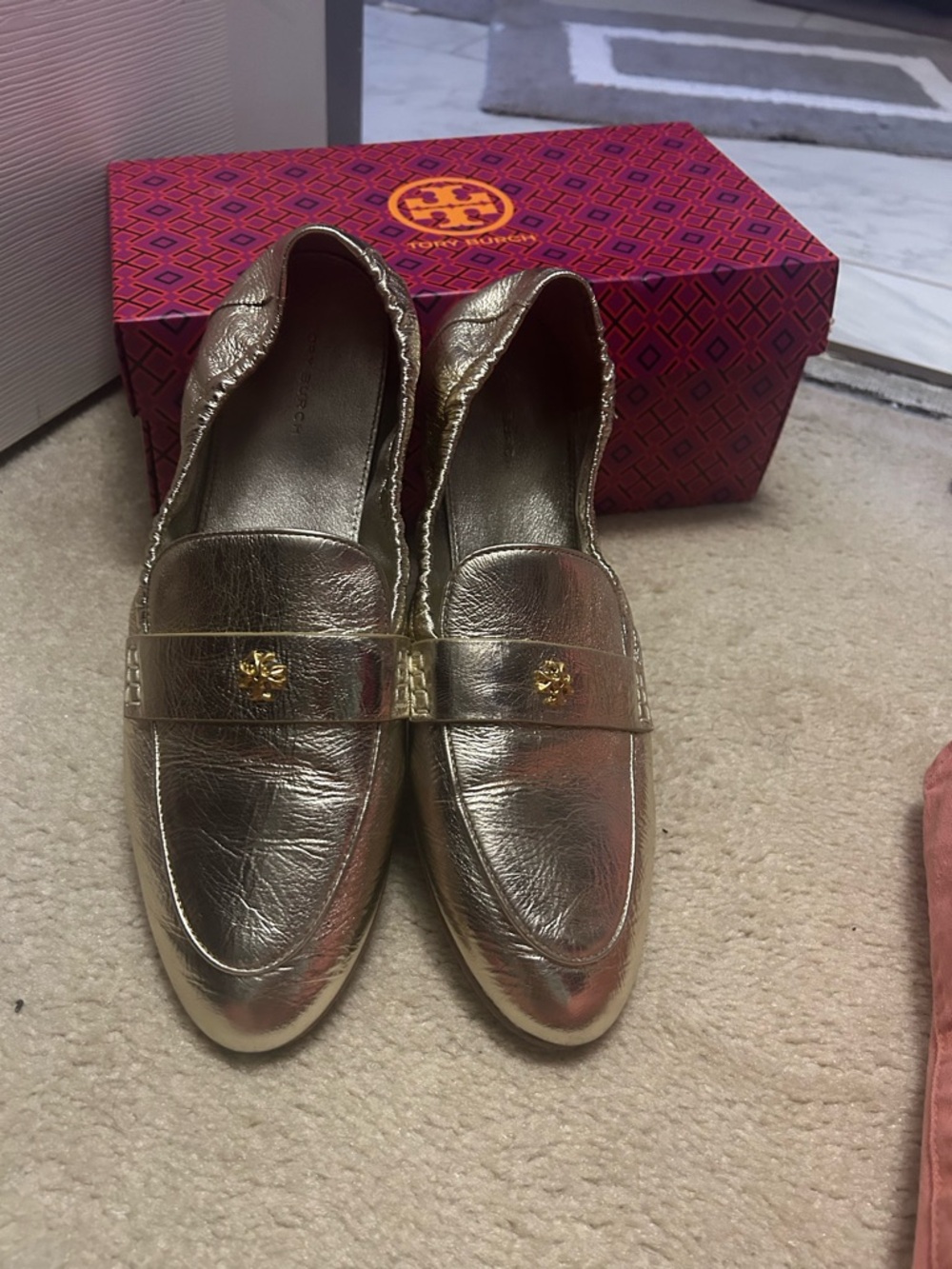 TORY BURCH gold loafers.